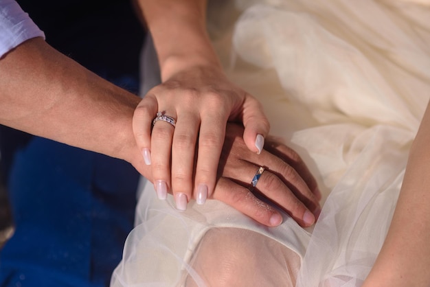 Gli sposi novelli della donna e dell'uomo si tengono per mano primo piano