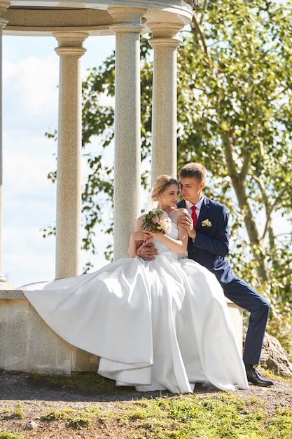 Gli sposi passeggiano nella natura nel Parco dopo la cerimonia nuziale Un bacio e un abbraccio da un uomo e una donna