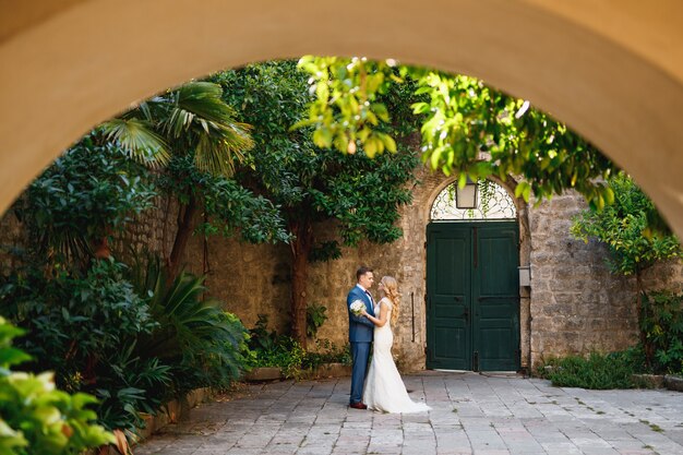 Gli sposi si abbracciano nel cortile della città vecchia di Perast