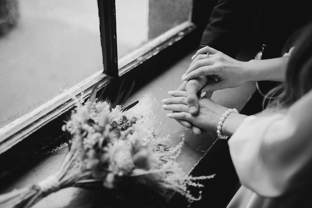Gli sposi si tengono per mano vicino al bouquet Sposa e sposo si tengono per mano vicino al bouquet da sposa elegante