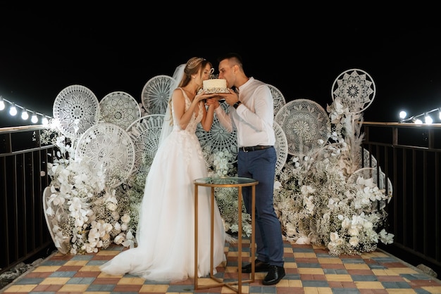 Gli sposi tagliano felicemente la risata e assaggiano la torta nuziale