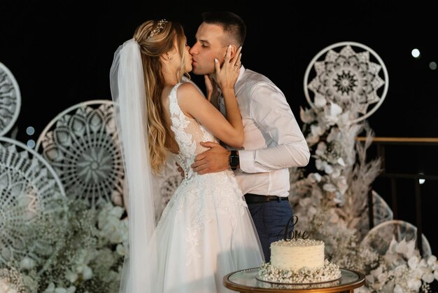 Gli sposi tagliano felicemente la risata e assaggiano la torta nuziale