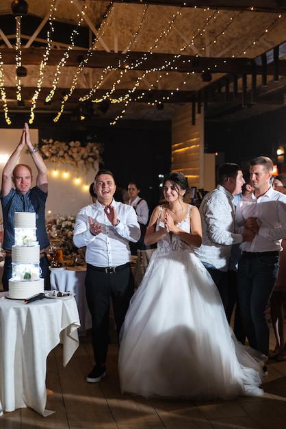 Gli sposi tagliano felicemente la risata e assaggiano la torta nuziale