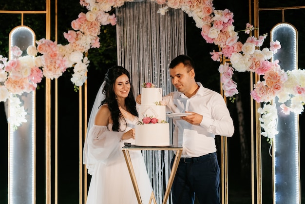 Gli sposi tagliano, ridono e gustano allegramente la torta nuziale