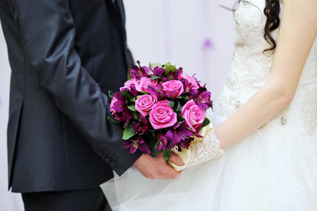 gli sposi tengono in mano un bellissimo bouquet da sposa