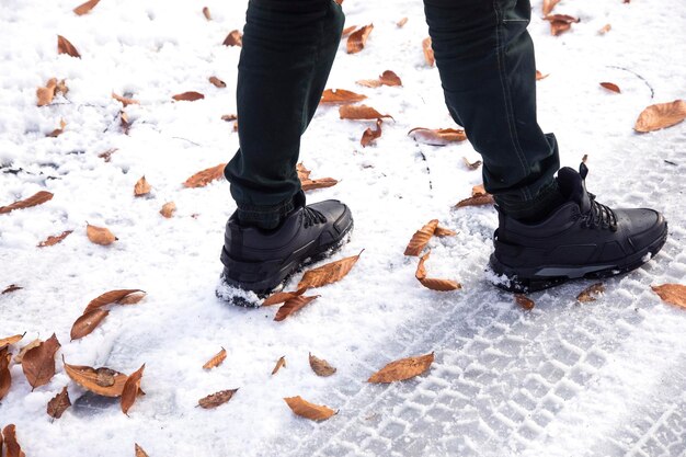 Gli stivali invernali neri stanno sulla neve