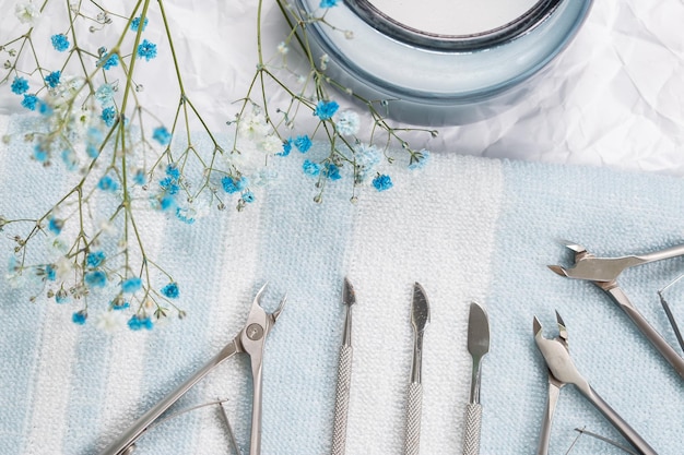 Gli strumenti per manicure sono disposti su un asciugamano a strisce bianco-blu, foto in studio.