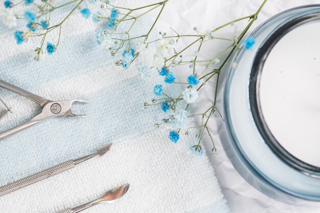 Gli strumenti per manicure sono disposti su un asciugamano a strisce bianco-blu, foto in studio.