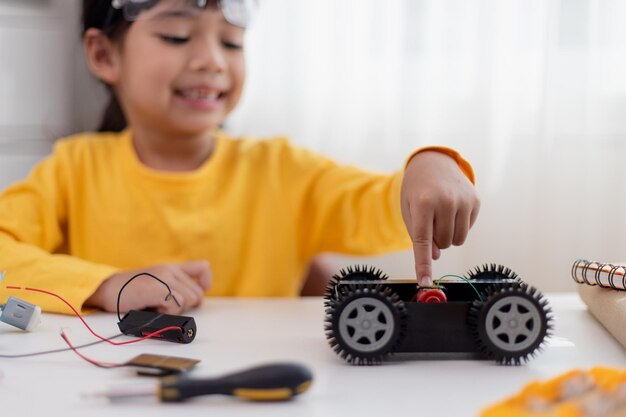 Gli studenti asiatici imparano a casa a codificare auto robot e cavi elettronici in STEM STEAM matematica ingegneria scienza tecnologia codice informatico in robotica per bambini concetto