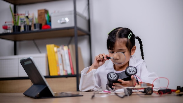 Gli studenti asiatici imparano a casa codificando auto robot e cavi di schede elettroniche in STEM STEAM matematica ingegneria scienza tecnologia codice computer in robotica per concetti per bambini