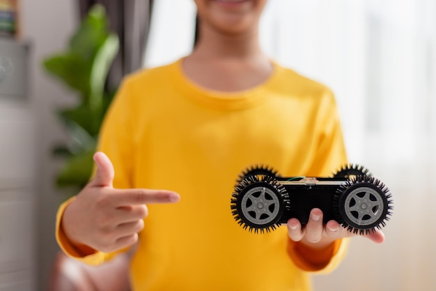 Gli studenti asiatici imparano a casa nella codifica di auto robot e cavi per schede elettroniche nel codice del computer STEM STEAM matematica ingegneria scienza tecnologia nel concetto di robotica per bambini