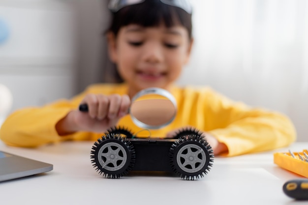 Gli studenti asiatici imparano a casa nella codifica di auto robot e cavi per schede elettroniche nel codice del computer STEM STEAM matematica ingegneria scienza tecnologia nel concetto di robotica per bambini