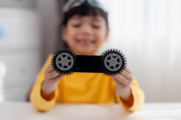 Gli studenti asiatici imparano a casa nella codifica di auto robot e cavi per schede elettroniche nel codice del computer STEM STEAM matematica ingegneria scienza tecnologia nel concetto di robotica per bambini