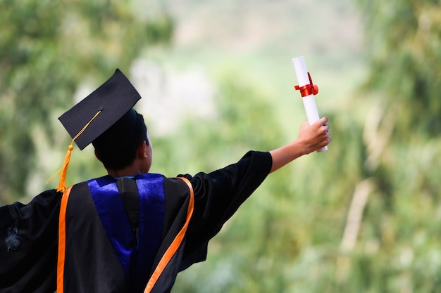 Gli studenti asiatici indossavano completi neri, cappelli neri, nappe gialle il giorno della laurea.