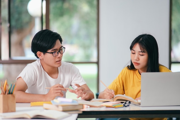 Gli studenti asiatici stanno leggendo libri e studiano tutoraggio insieme