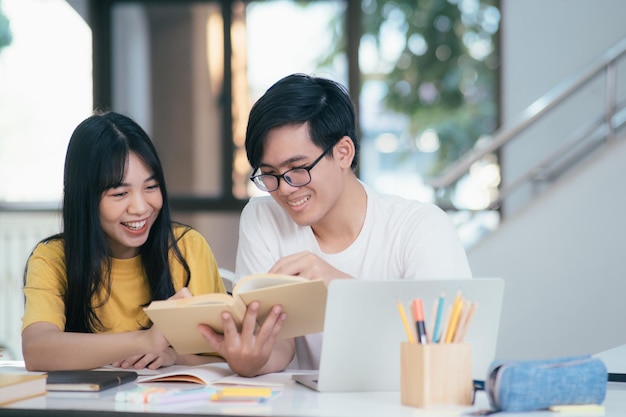 Gli studenti asiatici stanno leggendo libri e studiano tutoraggio insieme