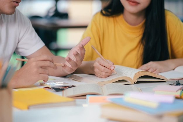 Gli studenti asiatici stanno leggendo libri e studiano tutoraggio insieme