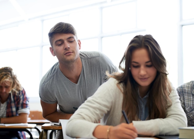 Gli studenti scrivono e imbrogliano in classe per l'apprendimento della conoscenza e lo sviluppo con appunti all'università L'istruzione maschile e il college con sbirciare all'esame di prova o la valutazione della ragazza in lezione