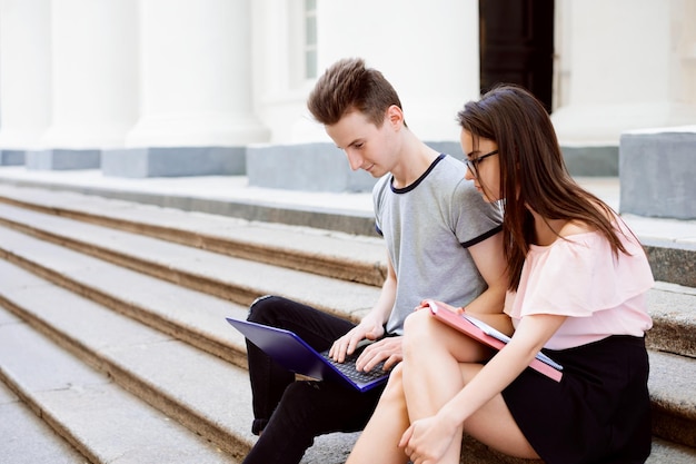 Gli studenti seduti sulle scale della vecchia università che lavorano al progetto comunicano