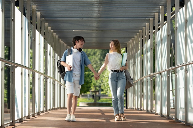 Gli studenti si accoppiano tenendosi per mano e camminando attraverso il corridoio