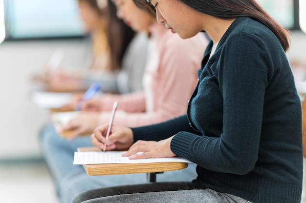 Gli studenti sostengono gli esami ai banchi dell'aula dell'università.