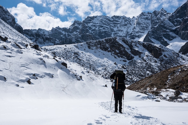 Gli uomini con lo zaino vanno in cima alla montagna in una giornata di sole