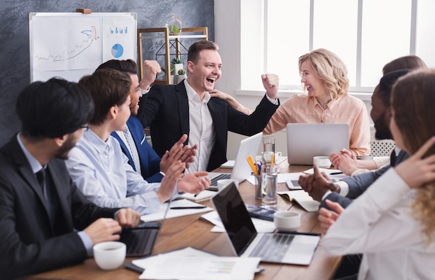 Gli uomini d'affari si congratulano con il collega per il suo successo durante la riunione d'affari