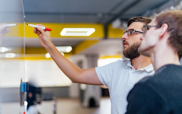 Gli uomini d'affari si incontrano in ufficio e usano le note post-it per condividere idee.