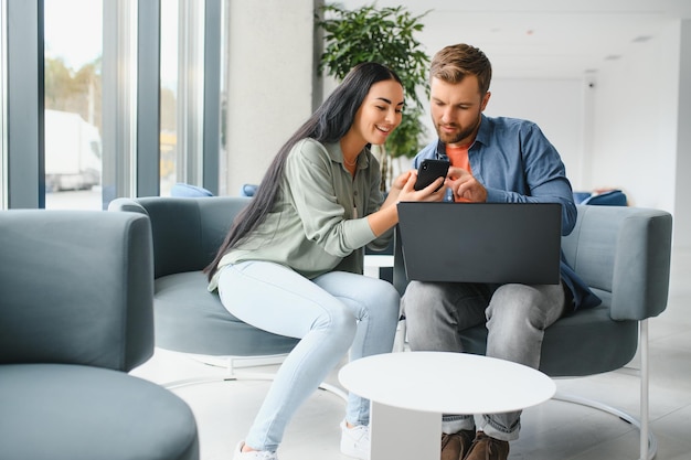 Gli uomini d'affari sorridenti lavorano collaborano al computer fanno un brainstorming sull'avvio dell'azienda durante una riunione in ufficio Diversi colleghi motivati guardano lo schermo del laptop discutono insieme idee di progetti aziendali