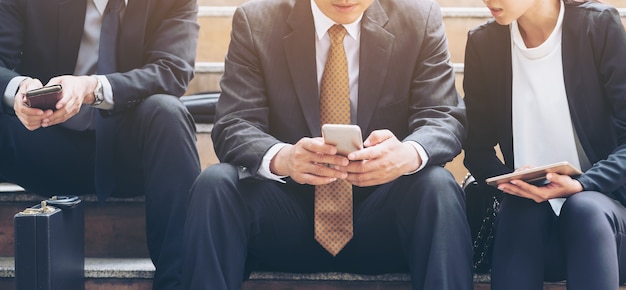 Gli uomini d&#39;affari utilizzano il telefono cellulare in città.