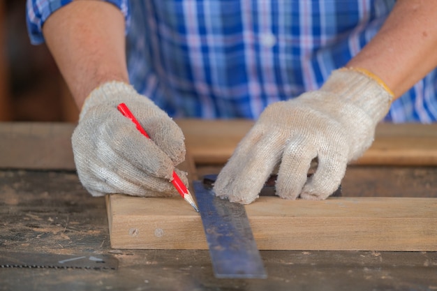 Gli uomini del carpentiere lavorano sulle misure di legno in un negozio di falegnameria.