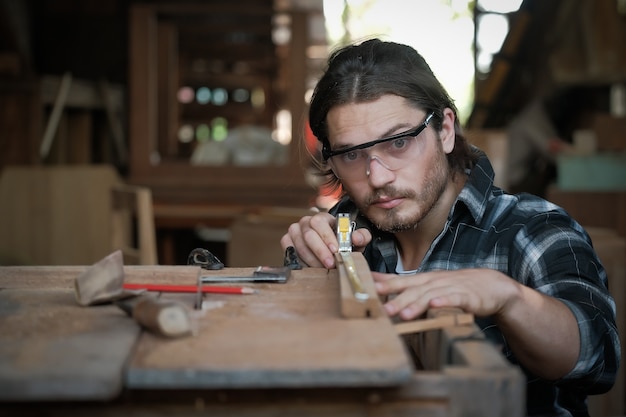 Gli uomini del falegname lavorano sulle misure del legno in una falegnameria.