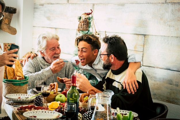 Gli uomini di famiglia felici si godono il pranzo di Natale insieme a casa