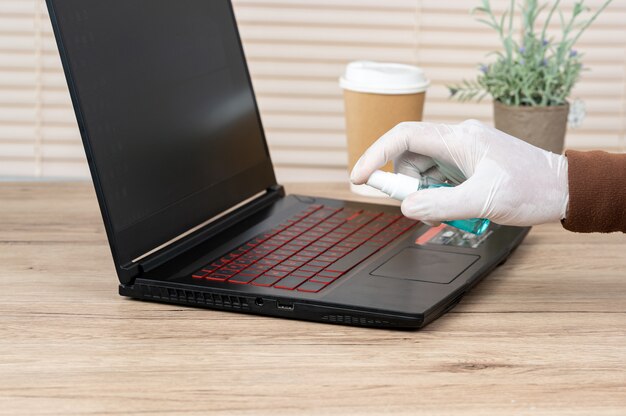 Gli uomini indossano guanti bianchi, usano alcol e spugna per pulire i laptop per prevenire i virus.