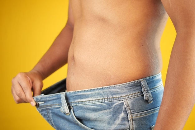 Gli uomini mettono i jeans e mostrano la perdita di peso