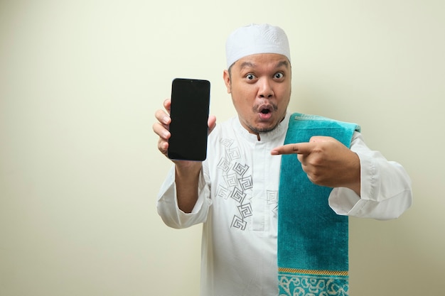 gli uomini musulmani asiatici grassi sembrano sorpresi dalle buone notizie che ha ricevuto dal suo smartphone
