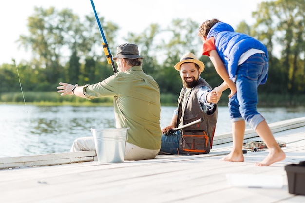 Gli uomini si sentono felici mentre pescano in famiglia