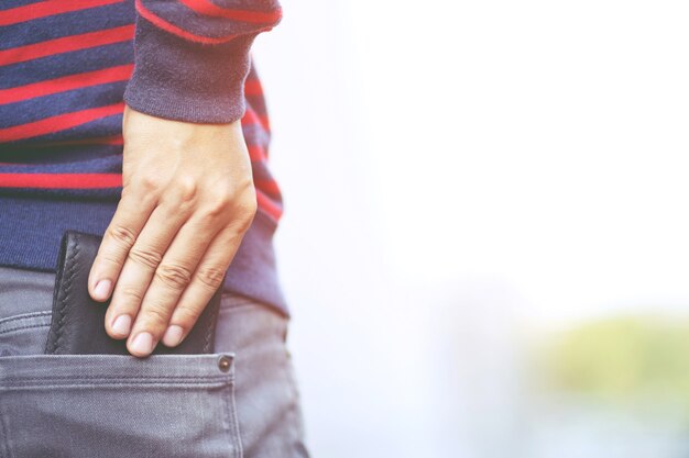 Gli uomini tengono un portafoglio da una tasca dei jeans.