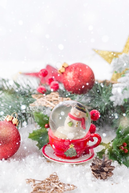 Globo di neve di Natale con rami di pino e decorazioni festive sul tavolo della neve. Concetto di Natale o Capodanno