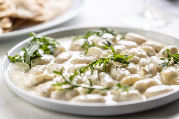 Gnocchi ai quattro formaggi Pasta di pasta italiana con quattro tipi di formaggio e rucola in cima