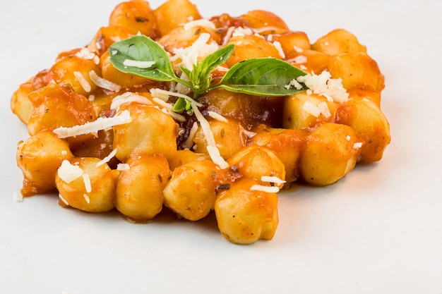 Gnocchi con salsa di sugo con formaggio grattugiato e basilico serviti nel piatto Messa a fuoco selettiva Vista dall'alto