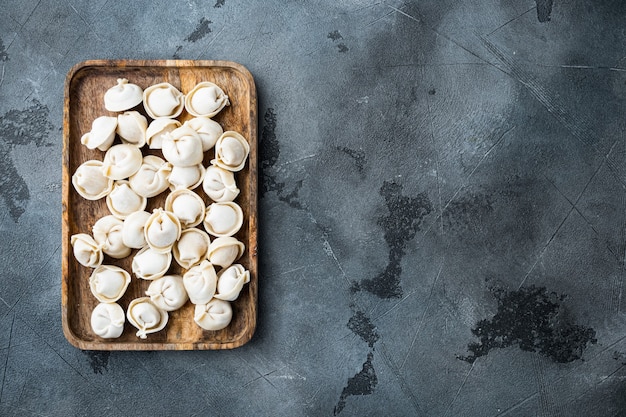 Gnocchi congelati tortellini e ravioli impostati in una scatola di legno, su sfondo grigio, vista dall'alto laici piatta, con copyspace e spazio per il testo