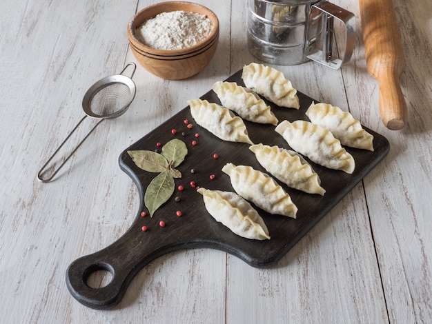 Gnocchi crudi congelati su una tavola di legno. Cibo tradizionale fatto in casa. Vista dall'alto.