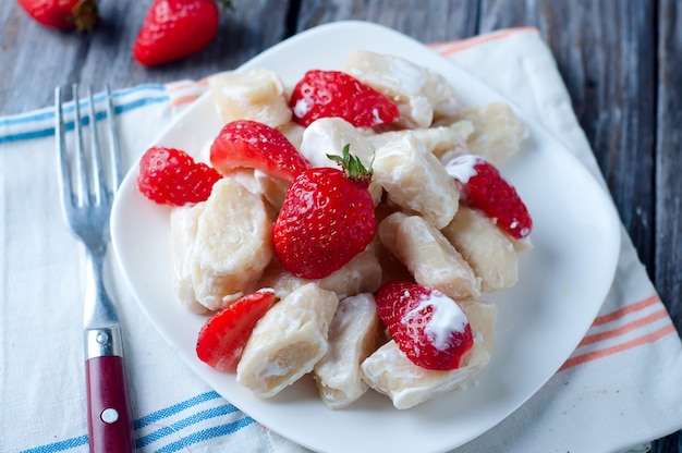 Gnocchi della ricotta con le fragole sulla vista superiore del fondo