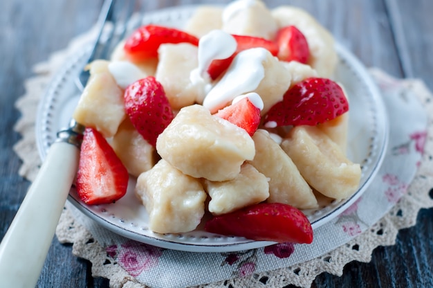 Gnocchi della ricotta con le fragole sulla vista superiore del fondo