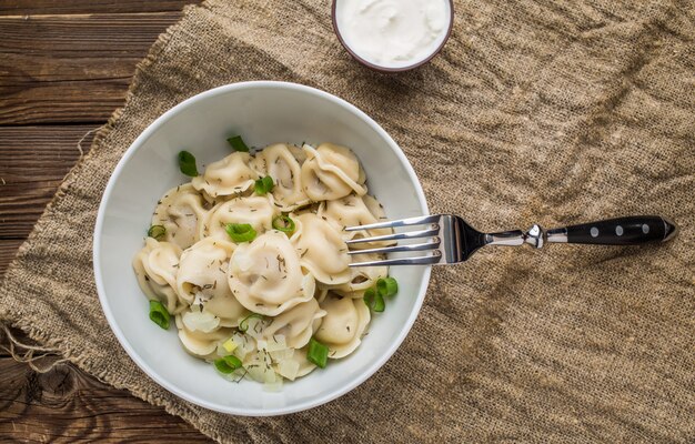 Gnocchi di carne - russo pelmeni, ravioli con carne su un piatto bianco