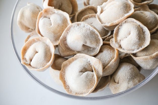 Gnocchi di carne tradizionali in un piatto trasparente dopo il congelamento per una cottura veloce