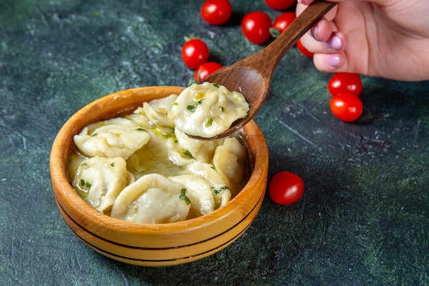 Gnocchi di carne vista frontale con pomodorini freschi su superficie scura