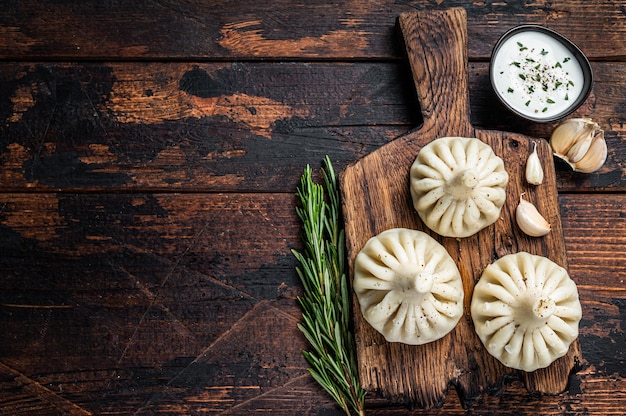 Gnocchi di Khinkali georgiani con carne di manzo e agnello su tavola di legno con erbe