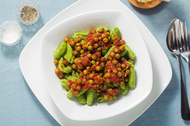 Gnocchi di pasta fresca tradizionale sarda italiana con spinaci e salsa di pomodoro verde piselli.